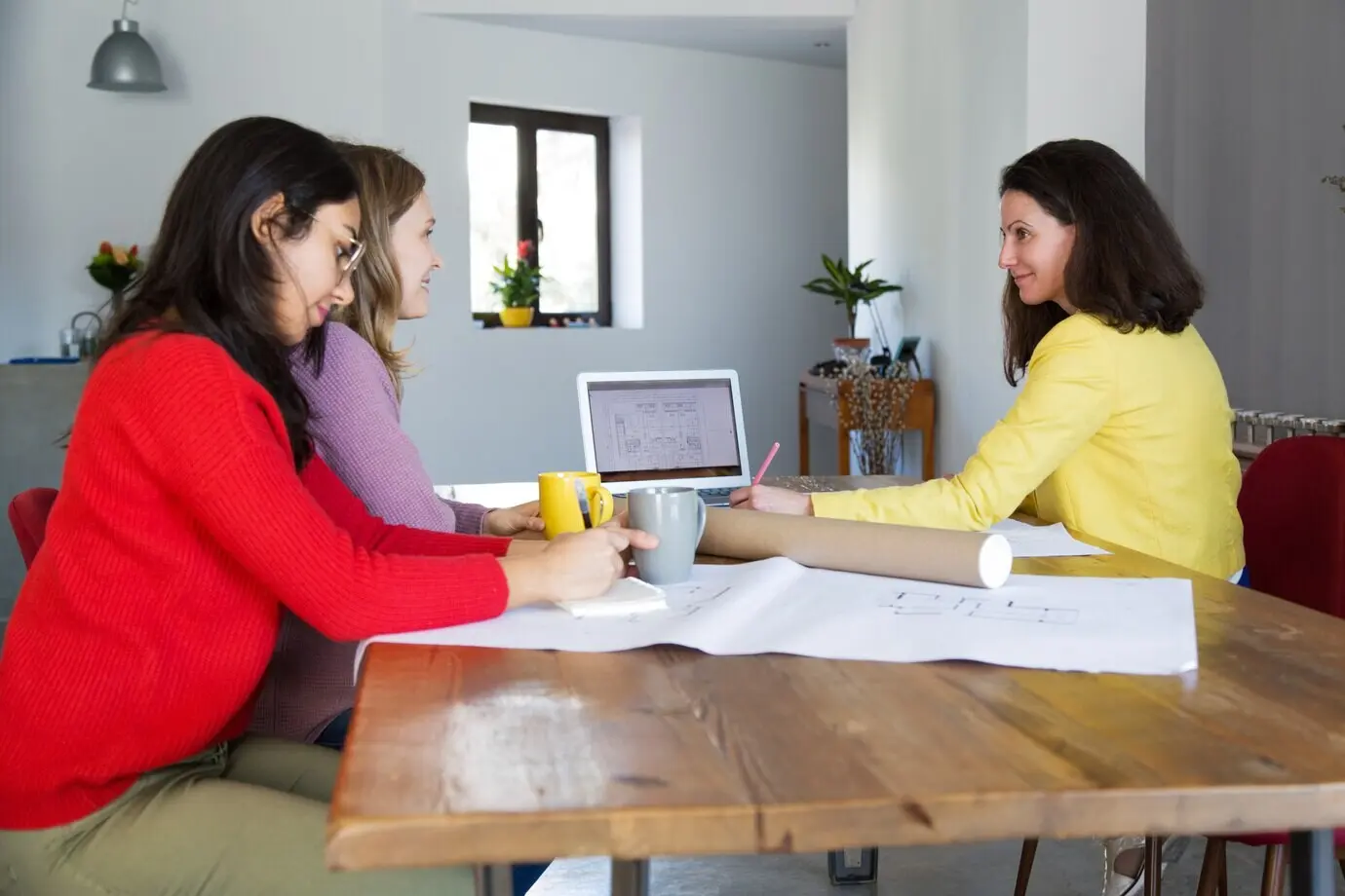 Architects working on drawings at a desk in an office